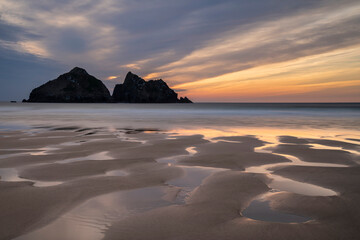 Absolutely stunning landscape images of Holywell Bay beach in Cornwall UK during golden hojur...