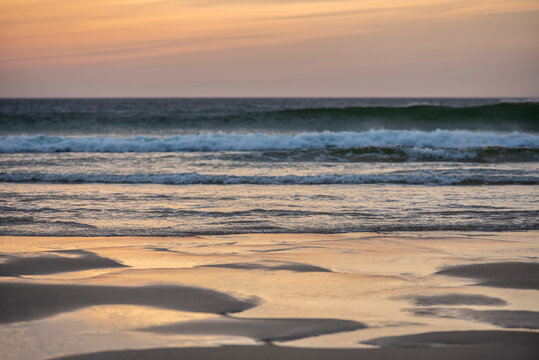 Absolutely stunning landscape images of Holywell Bay beach in Cornwall UK during golden hojur sunset in Spring