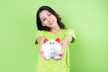 Fototapeta na wymiar asian girl holding piggy bank in her hand money saving concept