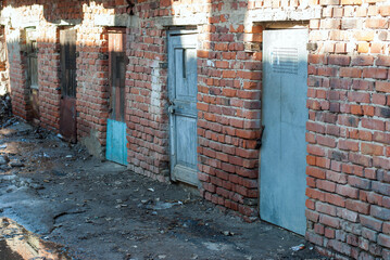 Old doors in a brick wall. Abandoned buildings in the city.