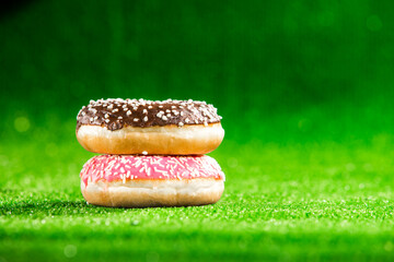 Sweet donut with sprinkel on green background	