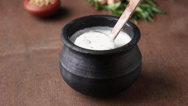 Pouring serving Spiced buttermilk , chaas , chaach , moru , sambharam , curd, lassi , yogurt, cool refreshing drink for hot summer in glass , Kerala, India Sri Lanka. Flavored Indian buttermilk.