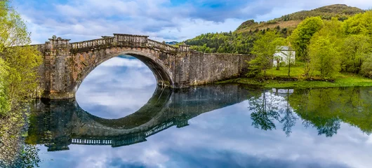 Foto auf Acrylglas A view of an old bridge on Loch Fyne near to Inveraray, Scotland on a summers day © Nicola