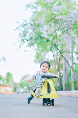 Baby boy riding trycycles.Little asian boy riding tolocar on the backyard.