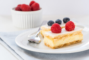 Traditional swiss custard slices with icing (Cremeschnitte in German) with fresh berries, close up
