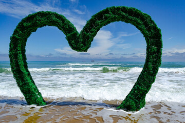 Fototapeta premium Sand beach with waves and a giant heart