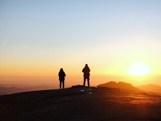 Fototapeta na wymiar Two hikers meet the winter sunset on the Moro rock in Sequoia & Kings Canyon National Park, California, USA