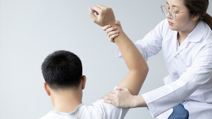 Obraz premium Physical therapy, Female physiotherapist treats arms and shoulders pain for a male patient attending in clinic, Bone arrangement, Non-surgical medical treatment, Modern medical techniques.