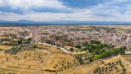 Capturas aéreas del municipio de Oropesa y de su famoso castillo medieval en la provincia de Toledo, y los campos castellanos y olivares durante la primavera en un día nublado, campo húmedo y marrón