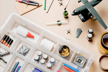 Model aircraft next to pains and brushes on desk