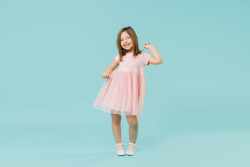 Fototapeta na wymiar Full size body length little fun cute kid girl 5-6 years old wears pink dress dancing isolated on pastel blue color background child studio portrait. Mother's Day love family people lifestyle concept.