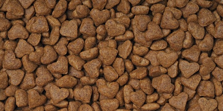 Heart shaped dryed food for cats and dogs. Panoramic background texture.	