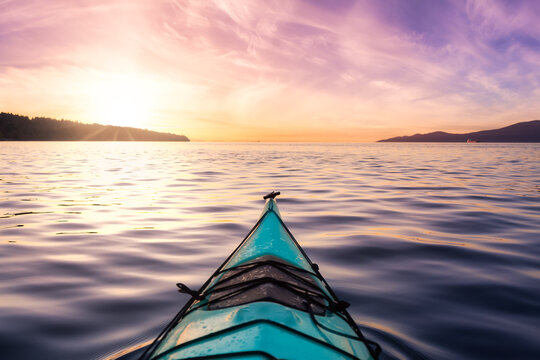 Sea kayaking in the Pacific Ocean on the West Coast. Colorful Sunset Sky Art Render. Taken in Jericho, Vancouver, British Columbia, Canada.