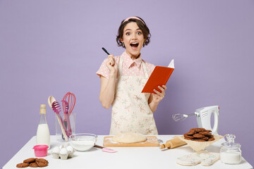 Young insighted proactive housewife housekeeper chef baker woman in pink apron work at table...