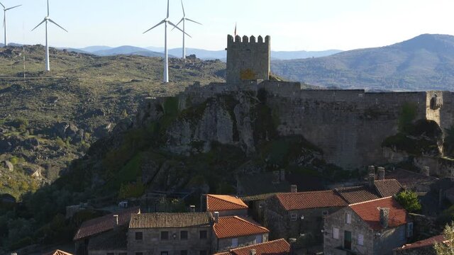 View of Sortelha castle and antique stone houses and wind turbines, in Portugal