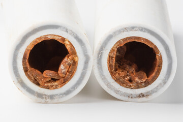 Old broken sludge plumbing polypropylene pipes with red rust and limescale. Corrosion, sludge and...