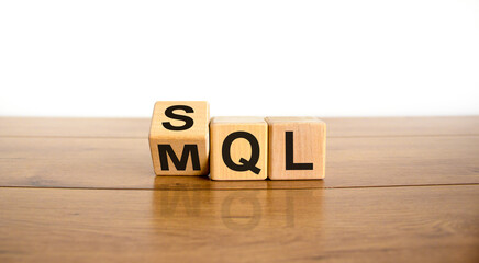 SQL or MQL symbol. Turned wooden cubes and changed words 'MQL marketing qualified lead' to 'SQL sales qualified lead'. Beautiful white background. Business and SQL or MQL concept. Copy space.