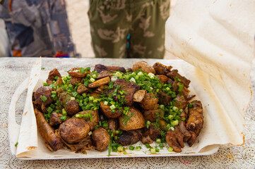 The prepared dish is fried potatoes, the meat is spread on the pita bread.
