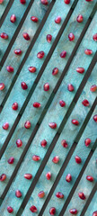 Red pomegranate seeds on a turquoise background. Diagonal line texture, top view. Background wallpaper for phone.