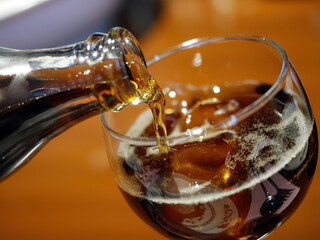 closed up pouring sparkling drinking beverage from bottle to glass