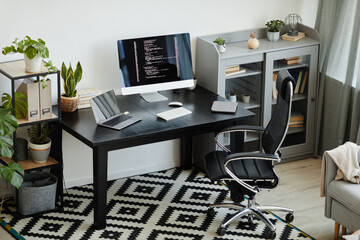 Image of modern office with table with computer monitor and laptop on it workplace for computer programmer