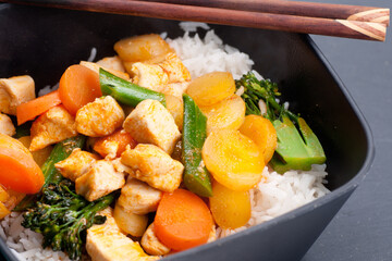 High angle shot of Thai coconut and mango curry with diced chicken and carrots over coconut rice