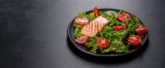 Delicious fresh salad with fish, tomatoes and lettuce leaves