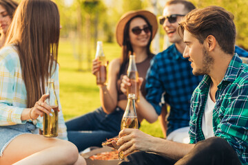 Group of friends having a picnic in the park on a sunny day, People hanging out, having fun while grilling and relaxing