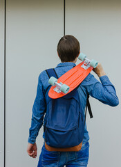 close up stylish man carrying the penny board in the summer city