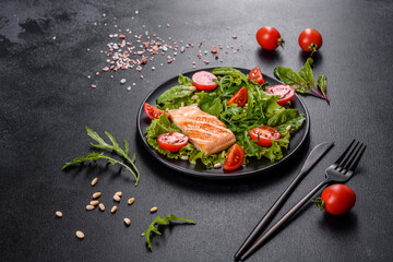 Delicious fresh salad with fish, tomatoes and lettuce leaves