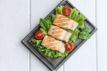 Delicious fresh salad with fish, tomatoes and lettuce leaves