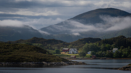 Low-hanging clouds over a farm in Norway.