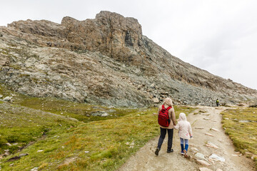 Fototapeta premium Mother and to children going for a walk in mountain surroundings