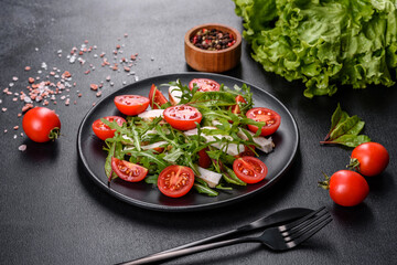 Pieces of chicken, tomatoes and lettuce leaves on a dark concrete background