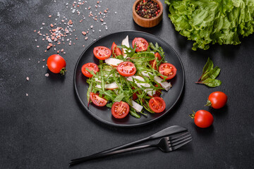 Pieces of chicken, tomatoes and lettuce leaves on a dark concrete background