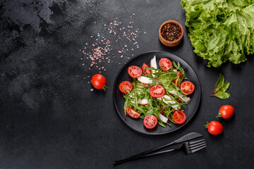 Pieces of chicken, tomatoes and lettuce leaves on a dark concrete background