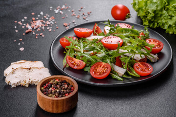 Pieces of chicken, tomatoes and lettuce leaves on a dark concrete background