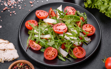Pieces of chicken, tomatoes and lettuce leaves on a dark concrete background