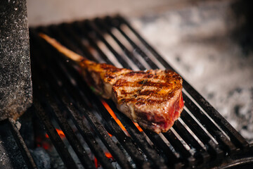 Juicy steak is grilled in a restaurant. Roasting meat in the fire on the grill.