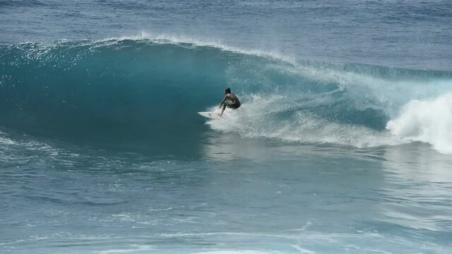 Surfing in Honolua Bay - A skillful surfer riding in and out and along the ridge of big blue breaking tidal waves in Honolua Bay at north-west coast of West Maui. Hawaii. USA.