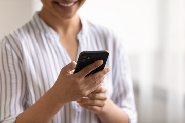 Crop close up of Indian woman hold use modern cellphone talk speak on video call on gadget online. Mixed race female look at smartphone screen text or browse internet on device. Technology concept.