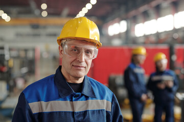 Portrait of content mature manufacturing worker