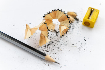 A sharpened pencil with shavings isolated with a white background.