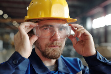 Factory worker adjusting protective goggles