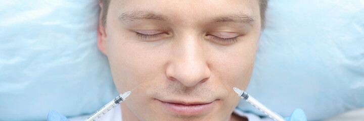 Fototapeta premium Male patient is given multiple injections into facial skin