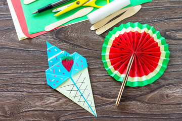 Paper Fan watermelon and origami paper ice cream on a wooden table. Childrens art project,...