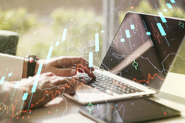 Double exposure of abstract creative financial chart with world map and with hands typing on computer keyboard on background, research and strategy concept