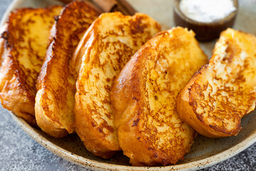 Torrijos close-up. Juicy, delicious, traditional Spanish dish. Dessert for breakfast with powdered sugar, cinnamon and lemon..