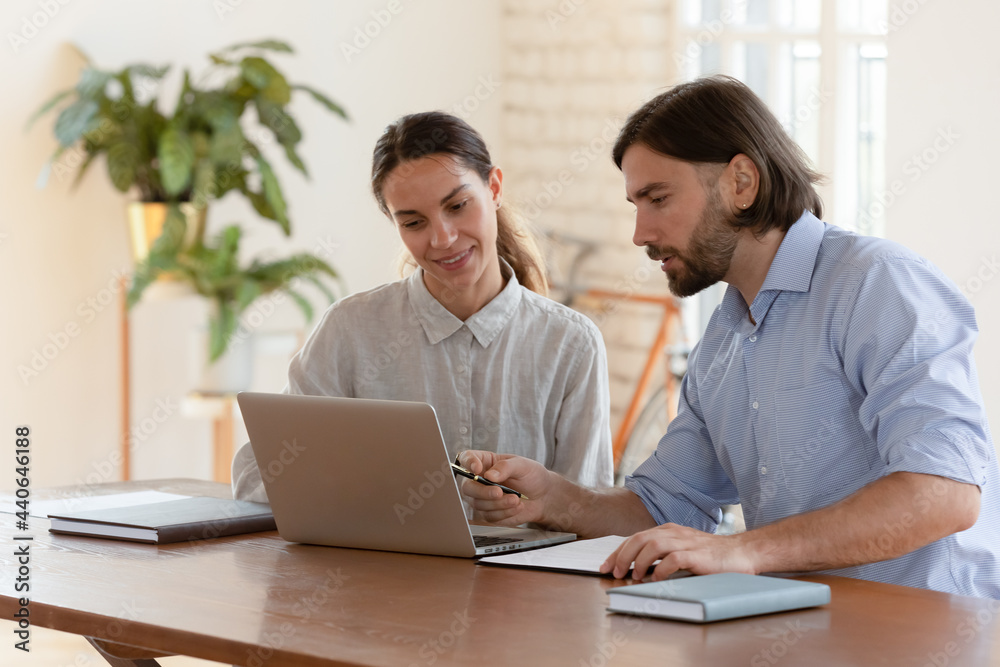 Wall mural businessman mentor teaching smiling female trainee, helping with corporate software, using laptop, p