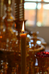 the lit church candles on a golden candlestick in the temple